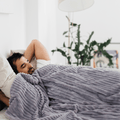 Model pod kołdrą obciążeniową Premium HuggyMoon z poszewką Minky w pasy szarą