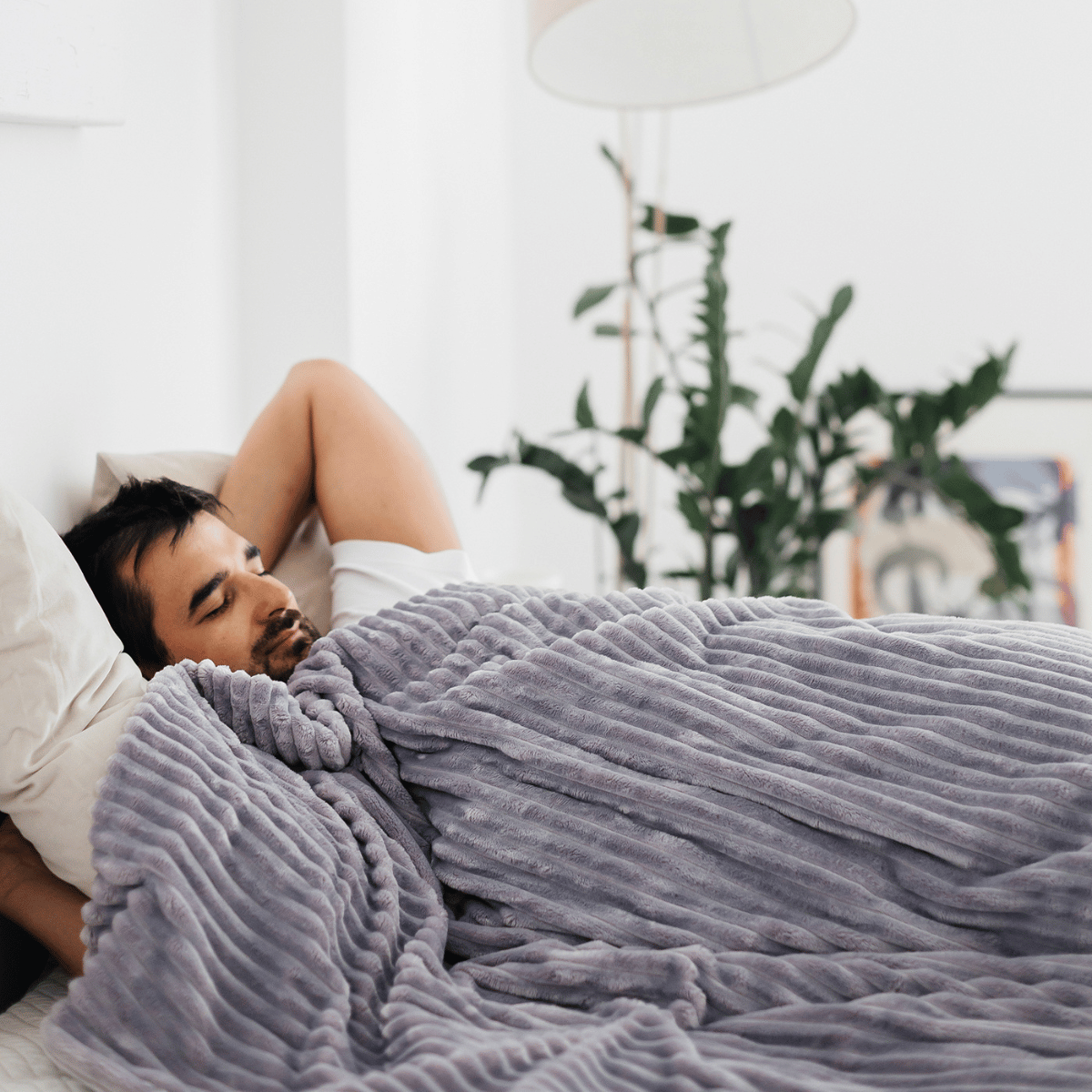 Model pod kołdrą obciążeniową Premium HuggyMoon z poszewką Minky w pasy szarą