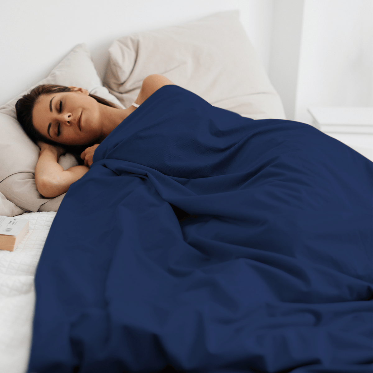 Modelka pod kołdrą obciążeniową Premium HuggyMoon z granatową poszewką Velvet – widok z boku